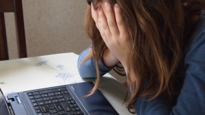 Teen girl anxious at computer